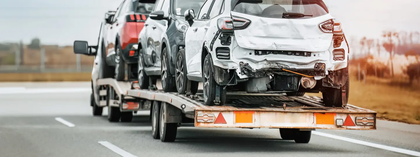 Abschleppwagen transportiert beschädigte Autos auf Autobahn